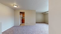 This single-floor unit at 6033 Bear Creek Dr in Bedford Heights, Ohio, offers a straightforward, functional layout with well-defined living spaces throughout. The open living area is finished with wall-to-wall carpet and neutral-toned walls, creating a clean, versatile backdrop. A textured ceiling and flush-mount lighting keep the space practical, while an open pass-through view into the kitchen adds a sense of connectivity between the two areas.

The kitchen is equipped with warm-toned wood cabinetry extending from base to upper wall level, providing generous storage. Countertops offer ample prep space, and the kitchen includes a white refrigerator, dishwasher, and gas range. Light ceramic tile flooring anchors the kitchen and complements the cabinetry tones.

The bedroom features carpet flooring, neutral walls, and a window that brings in natural light and exterior views. A closet with sliding doors provides dedicated storage space.

The bathroom maintains a clean, classic aesthetic with white tile surrounding the tub-shower combination, mosaic tile flooring, a white vanity with storage drawers, a single sink, and a large mirror. The overall ambiance of the unit is practical and move-in ready, with a simple, consistent design throughout.