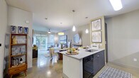 This thoughtfully designed 1-bedroom, 2-bathroom residence spans a single floor and makes efficient use of its space through an open-concept layout. Polished concrete floors flow throughout, giving the home a sleek, contemporary feel.

The kitchen serves as a central hub, featuring granite countertop surfaces, dark cabinetry, a subway tile backsplash, black appliances including a gas range and French door refrigerator, and a peninsula with bar seating illuminated by modern pendant lighting. The kitchen opens seamlessly into the combined dining and living area, which is bathed in natural light from floor-to-ceiling sliding glass doors that lead to a private balcony overlooking lush outdoor greenery.

The bedroom offers a comfortable retreat with a large window framing outdoor views, a ceiling fan, and direct access to a dedicated closet for ample storage. Two full bathrooms serve the residence; one features a elongated vanity with granite counters, dark wood cabinetry, a large mirror, and a tub-shower combination with clean white subway tile surround.

The overall ambiance is modern and cohesive, with neutral tones, warm accent lighting, and stylish finishes that create an inviting and functional living environment.