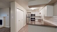 Located at 1213 Vincent St in Fort Worth, TX, this single-story, one-bedroom unit offers a well-organized layout designed for comfortable everyday living. The open living area is a standout feature, showcasing wood-style plank flooring, a ceiling fan with light fixture, and a classic white-mantled fireplace flanked by built-in shelving. A large arched window allows natural light to fill the space, while neutral gray walls create a clean, versatile backdrop. Built-in shelving along one wall adds functional display and storage space.

The kitchen is thoughtfully equipped with stainless steel appliances—including a refrigerator, range, and over-the-range microwave—complemented by white shaker-style cabinetry, a white subway tile backsplash, and a dark countertop. A pass-through opening connects the kitchen to the living area, enhancing the sense of openness.

The bedroom features a large window with natural light and a sliding closet door providing convenient storage. An additional walk-in closet is accessible from the hallway, offering generous storage capacity. The bathroom includes a combination tub and shower with a curtain rod, toilet, and light wood-style flooring consistent with the rest of the unit. Textured ceilings are present throughout the space.