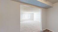 Located in Denver, CO 80227, this single-floor residence offers a well-organized two-bedroom, two-bathroom layout designed for comfortable everyday living. The open living room features plush wall-to-wall carpeting, vertical blinds allowing natural light to filter in, and a textured ceiling, creating a bright and welcoming common area. A hallway connects the main living spaces to the private quarters, maintaining a functional flow throughout.

The kitchen is equipped with white shaker-style cabinetry, granite-look countertops, a stainless steel sink, and wood-look flooring, offering a clean and updated aesthetic. Ample cabinet space provides practical storage for daily needs.

The primary bedroom is generously sized, featuring carpeted floors, a large window with vertical blinds, and access to a walk-in closet outfitted with dual hanging rods and shelving on multiple levels. The second bedroom mirrors similar finishes, with carpet, a bright window, and closet access. In total, four closets are distributed throughout the home, ensuring abundant storage options.

Both bathrooms include a full tub-shower combination with white square tile surrounds and chrome fixtures, with one bathroom featuring an accessibility grab bar. The overall palette of neutral whites and warm beiges lends the space a clean, move-in-ready character.