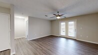 This thoughtfully designed single-floor residence offers 1 bedroom and 1 bathroom across a practical and efficient layout. The open-concept living room and kitchen area forms the heart of the home, finished with rich hardwood-style flooring and neutral-toned walls that create a clean, welcoming atmosphere. A ceiling fan with a built-in light fixture keeps the space comfortable, while a set of French doors floods the room with natural light and opens directly onto a private balcony — perfect for enjoying outdoor views. The textured ceiling adds a classic touch throughout the main living areas.

The galley-style kitchen is well-equipped, featuring crisp white cabinetry with modern hardware, light stone-look countertops, stainless steel appliances including a range, microwave, dishwasher, and refrigerator, along with a single-basin sink. Light wood-tone flooring ties the kitchen seamlessly into the rest of the home.

The bedroom is a comfortable retreat, complete with its own ceiling fan, a window allowing natural light, and direct access to the closet. The full bathroom is finished with white cabinetry, a large mirror with overhead lighting, a single-sink vanity, and a full bathtub and shower combination. A dedicated closet provides additional storage, completing this efficient and functional home.