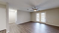 This thoughtfully designed single-floor residence offers 1 bedroom and 1 bathroom across a practical and efficient layout. The open-concept living room and kitchen area forms the heart of the home, finished with rich hardwood-style flooring and neutral-toned walls that create a clean, welcoming atmosphere. A ceiling fan with a built-in light fixture keeps the space comfortable, while a set of French doors floods the room with natural light and opens directly onto a private balcony — perfect for enjoying outdoor views. The textured ceiling adds a classic touch throughout the main living areas.

The galley-style kitchen is well-equipped, featuring crisp white cabinetry with modern hardware, light stone-look countertops, stainless steel appliances including a range, microwave, dishwasher, and refrigerator, along with a single-basin sink. Light wood-tone flooring ties the kitchen seamlessly into the rest of the home.

The bedroom is a comfortable retreat, complete with its own ceiling fan, a window allowing natural light, and direct access to the closet. The full bathroom is finished with white cabinetry, a large mirror with overhead lighting, a single-sink vanity, and a full bathtub and shower combination. A dedicated closet provides additional storage, completing this efficient and functional home.