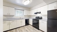 Located at 4035 Westminster Pl in St. Louis' Central West End neighborhood, this two-story residence offers two bedrooms and two bathrooms across a well-proportioned layout split evenly between both floors. The main level features a bright, functional kitchen outfitted with white cabinetry, gray speckled countertops, black appliances including a range, dishwasher, and refrigerator, and light wood-style vinyl flooring. A window above the sink allows natural light to fill the space. Adjacent to the kitchen, a dedicated in-unit laundry area provides added convenience. The open flow between the kitchen and living areas is reinforced by neutral gray walls and consistent flooring throughout the main level. The upper floor hosts the bedrooms, each featuring soft carpeting, neutral gray walls, and windows that bring in natural light and neighborhood views. The spacious primary bedroom offers ample room for furnishings. The bathrooms are finished with wood-style vinyl flooring and clean white tile surrounds in the tub-shower combinations. A hallway connects the upper-level rooms, complemented by a closet for storage. The consistent, clean aesthetic throughout creates a cohesive and comfortable living environment.
