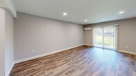 Located at 109 Alexandra Drive in Laconia, NH, this contemporary 2-bedroom, 3-bathroom home spans three floors, offering a well-proportioned and functional layout throughout. The entry level provides a generous living area with recessed lighting and durable wood-look flooring in a warm tone, lending a clean, modern aesthetic. A sliding glass door opens to the outdoors, filling the space with natural light, while a wall-mounted mini-split unit ensures year-round comfort.

The main floor serves as the heart of the home, featuring a well-appointed kitchen with slate-blue shaker cabinetry, white quartz countertops, a subway tile backsplash, stainless steel appliances, and warm hardwood flooring. Natural light flows in through a bright window, adding to the inviting atmosphere. A bathroom on this level mirrors the kitchen's design with matching gray cabinetry, white countertops, and matte black hardware.

The upper floor houses both bedrooms, each finished with plush carpeting and ceiling fans. The primary bedroom is comfortably sized, while the second bedroom includes a built-in closet with shelving. The bathrooms throughout echo a consistent modern palette of neutral tones and matte black accents. Staircases connect all three levels seamlessly, completing this cohesive and well-finished home.