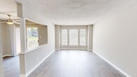 Located at 208 Club Pkwy in Norcross, GA, this well-appointed 2-bedroom, 1-bathroom home offers a thoughtfully designed single-floor layout. The bright and open living area makes a strong first impression, featuring light-toned wood-look flooring, neutral warm-gray walls, a textured ceiling, and a trio of windows that flood the space with natural light. A pass-through opening connects the living area to the kitchen, enhancing the open feel. The kitchen is equipped with stainless steel appliances including a gas range and refrigerator, crisp white shaker cabinets, a classic subway tile backsplash, and matching wood-look flooring. Both bedrooms are carpeted and offer a comfortable sense of space, with windows providing natural light and outdoor views. The spacious primary bedroom features dual closets with wire shelving for generous storage. The full bathroom includes an extended vanity with white countertops, a large mirror, and a separate wet room with a soaking tub. A dedicated laundry room houses a full-size washer and dryer with overhead wire shelving. The home's clean, neutral palette and updated finishes throughout create a move-in-ready, functional living environment.