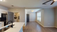 This single-story, 1-bedroom, 1-bathroom residence in Baton Rouge, Louisiana offers a thoughtfully designed open-concept layout that maximizes functionality and comfort. The living area features warm hardwood-style flooring, crown molding, and a ceiling fan, creating a bright and welcoming atmosphere. Natural light flows in through multiple windows fitted with blinds, while French doors provide access to a private balcony, extending the living space outdoors.

The kitchen is a standout feature, equipped with white shaker cabinetry, a subway tile backsplash, stainless steel appliances including a range and microwave, and a quartz countertop peninsula with a double-basin sink. The peninsula opens directly to the living area, making it ideal for both everyday living and entertaining.

The bedroom is generously sized with a ceiling fan, two windows that invite natural light, and hardwood-style flooring. A dedicated in-unit laundry area adds everyday convenience. The bathroom features a white vanity with quartz countertops, mixed-finish hardware, a large wall mirror, and a stylish light fixture overhead. The neutral color palette and clean finishes throughout create a cohesive, modern aesthetic well-suited to comfortable living in the heart of Baton Rouge.