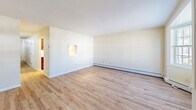 Located at 235 W Main St in Stamford, Connecticut, this three-bedroom, two-bathroom residence spans three floors, offering a well-organized and functional layout throughout. The space is characterized by light wood flooring that runs consistently across the living areas and bedrooms, complementing the warm, neutral tones of the walls and creating a bright, cohesive interior.

The ground floor includes an attached garage with automatic opener, providing convenient enclosed parking and additional storage potential. Hallways on multiple levels connect the home's spaces with ease, while a central staircase links all three floors.

The main living level features open, airy rooms with baseboard heating and large windows that invite natural light. The kitchen area connects to the living spaces, making the floor practical for daily living.

The three bedrooms are generously proportioned, with the primary bedroom offering the most expansive footprint. Bedrooms feature light wood flooring, ample closet space with double bifold doors, and windows providing natural light. The uppermost floor offers a more intimate setting, ideal for a private retreat or home office.

Both bathrooms are finished with tile flooring and include full tub-shower combinations with built-in shelving, vanities with mirrors, and clean white fixtures throughout. The overall ambiance is clean, bright, and move-in ready.