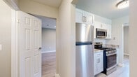 This two-story home in Lancaster, PA offers a thoughtfully designed layout with three bedrooms, two full bathrooms, and two living areas spread across two well-proportioned floors. The main level features a bright, galley-style kitchen outfitted with stainless steel appliances — including a gas range, built-in microwave, dishwasher, and full-size refrigerator — complemented by white shaker cabinetry, stone-look countertops, and light hardwood-style flooring. The kitchen opens to an adjacent living area filled with natural light from large windows. A dedicated utility room provides added convenience on this level. The main living room impresses with vaulted-style ceilings, recessed lighting, and an open staircase with sleek black metal railings leading to the upper floor. Upstairs, the three bedrooms are carpeted for comfort, each featuring ceiling fans and ample closet space with bifold doors. The primary bedroom offers generous proportions. The two bathrooms are finished with large-format neutral tile — one featuring a walk-in glass shower, the other a soaking tub with shower combo and chrome fixtures. Neutral gray tones, clean white trim, and consistent hardwood-style flooring throughout the main level create a cohesive, modern aesthetic across the entire home.