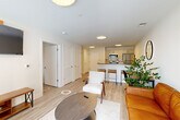 Located at 72 South Essex Avenue in Orange, NJ, this well-appointed one-bedroom, one-bathroom residence offers a thoughtfully designed open-concept floor plan with modern finishes throughout. Light wood-tone flooring flows seamlessly across the living, dining, and kitchen areas, creating a cohesive and airy feel.

The kitchen is a standout feature, equipped with stainless steel appliances including a gas range, microwave, refrigerator, and dishwasher. Sleek dark countertops contrast beautifully with light cabinetry, and a peninsula with bar seating makes the space ideal for both everyday dining and entertaining.

The combined living and dining area is bright and inviting, anchored by large windows and a glass door that opens onto a private balcony with urban views. The bedroom is comfortably scaled, featuring a window with natural light and outdoor views, and is complemented by a generously sized walk-in closet outfitted with wire shelving and built-in drawer storage.

The bathroom is clean and contemporary, featuring large-format tile surrounding a full soaking tub with overhead shower, a floating vanity, and polished chrome fixtures. Additional conveniences include in-unit laundry, a utility room, and two closets, making this a highly functional and stylish urban residence.
