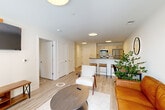 Located at 72 South Essex Avenue in Orange, NJ, this well-appointed one-bedroom, one-bathroom residence offers a thoughtfully designed open-concept floor plan with modern finishes throughout. Light wood-tone flooring flows seamlessly across the living, dining, and kitchen areas, creating a cohesive and airy feel.

The kitchen is a standout feature, equipped with stainless steel appliances including a gas range, microwave, refrigerator, and dishwasher. Sleek dark countertops contrast beautifully with light cabinetry, and a peninsula with bar seating makes the space ideal for both everyday dining and entertaining.

The combined living and dining area is bright and inviting, anchored by large windows and a glass door that opens onto a private balcony with urban views. The bedroom is comfortably scaled, featuring a window with natural light and outdoor views, and is complemented by a generously sized walk-in closet outfitted with wire shelving and built-in drawer storage.

The bathroom is clean and contemporary, featuring large-format tile surrounding a full soaking tub with overhead shower, a floating vanity, and polished chrome fixtures. Additional conveniences include in-unit laundry, a utility room, and two closets, making this a highly functional and stylish urban residence.