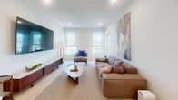 Located in the Koreatown neighborhood of Los Angeles, this single-floor, 3-bedroom, 2-bathroom home offers a thoughtfully designed layout with modern finishes throughout. Light wood flooring runs through the main living areas and hallways, complementing the clean white walls and recessed lighting that give the space a bright, airy feel.

The open-concept living room is generously sized, featuring multiple windows that bring in natural light and offer neighborhood views. The kitchen is well-appointed with sleek gray cabinetry, quartz countertops, a marble-style tile backsplash, stainless steel appliances including a French door refrigerator, range, and dishwasher, plus an island with additional counter space.

The primary bedroom is spacious and features a large window with outdoor views, a closet, and carpeted flooring. Additional bedrooms offer versatile space, with one currently configured as a home office with light wood flooring. A bright hallway connects the private sleeping quarters to the rest of the home.

Both bathrooms are finished in a contemporary style. The primary bath features a wide vanity with gray cabinetry, quartz countertops, a large mirror, and a glass-enclosed shower. The second bathroom also includes a glass-enclosed walk-in shower. A dedicated laundry room houses a stacked washer and dryer unit for added convenience.