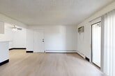 Located at 1211 South Quebec Way in Denver, CO, this 2-bedroom, 2-bathroom home offers a well-organized single-level layout designed for comfortable everyday living. The living room is a standout space, featuring light hardwood-style flooring, a classic fireplace with a white surround, and a sliding glass door that opens to a private balcony, allowing natural light to fill the room. A wall-mounted AC unit and baseboard heating ensure year-round comfort. The galley-style kitchen is efficiently designed with white cabinetry, white countertops, and black appliances including a range and refrigerator, complemented by a stainless steel dishwasher and sink. Hardwood-style flooring carries through the kitchen, adding continuity to the space. Both bedrooms are carpeted and offer a quiet, neutral atmosphere. The spacious primary bedroom includes a double-door louvered closet, providing ample storage. The secondary bedroom benefits from natural light through a window and features a dedicated closet and direct access to a full bathroom. Both bathrooms are clean and functional, each featuring a full tub-shower combination with white tile surround. Textured ceilings are present throughout the home, adding a consistent architectural finish across all rooms.