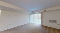 Located at 2034 Flintshire Rd in Rosedale, Maryland, this single-floor, 1-bedroom, 1-bathroom apartment offers a straightforward and functional layout. The living area is a standout feature, boasting wall-to-wall carpeting and a large sliding glass door dressed with vertical blinds that floods the room with natural light and provides views of the surrounding greenery. An HVAC vent and wall unit ensure year-round climate comfort, while clean white walls create a bright, neutral backdrop throughout.

The entry foyer transitions seamlessly into the main living space, featuring tile flooring and a classic paneled door. The kitchen is equipped with warm-toned wooden cabinetry, granite-style countertops, a gas range, and a refrigerator, all set atop elegant marble-look tile flooring that adds a clean, polished aesthetic.

The bedroom is a well-proportioned, carpeted room with a window fitted with vertical blinds, allowing for natural light while maintaining privacy. An additional carpeted room offers flexible use as a secondary space or home office.

The bathroom features a full tub-shower combination with floor-to-ceiling marble-style tile surround and brushed nickel fixtures, lending a clean and classic finish. Overall, this apartment presents a practical and comfortable living environment in the Rosedale community.