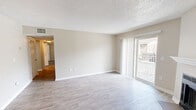 Located at 1811 W Lakeview Dr in Johnson City, TN, this 2-bedroom, 2-bathroom single-floor residence offers a thoughtfully designed layout with clean, neutral finishes throughout. The open living room is a standout space, featuring light-toned luxury vinyl plank flooring, a textured ceiling, a wood-burning fireplace with a white mantel, and a sliding glass door that fills the room with natural light and provides access to an outdoor balcony. The kitchen is efficiently arranged in a U-shaped layout, equipped with gray shaker-style cabinetry, light countertops, stainless steel appliances including a range, dishwasher, and refrigerator, and matching luxury vinyl plank flooring. Both bedrooms are carpeted and include ceiling fans with light fixtures. The primary bedroom offers a generous footprint with a built-in closet featuring a rod and shelf system. The second bedroom includes a window that brings in natural light. Both bathrooms are finished with gray vanity cabinetry, light countertops, vinyl plank flooring, and tub-shower combinations. A hallway connects the bedrooms and bathrooms, with an additional closet providing extra storage. The space maintains a consistent, neutral color palette throughout, creating a cohesive and move-in-ready environment.