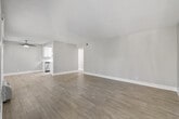 This thoughtfully designed 2-bedroom, 1-bathroom residence is laid out on a single floor, offering a practical and comfortable living environment. The open living room is a standout feature, showcasing light gray wood-look flooring, neutral-toned walls, a textured ceiling, and a ceiling fan. Large windows allow natural light to fill the space, and a wall-mounted HVAC unit provides convenient climate control. The layout flows seamlessly from the living area toward the hallway, which connects all rooms efficiently.

The galley-style kitchen is outfitted with crisp white cabinetry, light countertops, a subway tile backsplash, a stainless steel sink, and a full suite of stainless steel appliances including a gas range, refrigerator, and dishwasher — offering both style and functionality.

Both bedrooms feature plush carpeting and neutral walls. The primary bedroom includes a sliding glass door opening to a private outdoor balcony with exterior views, as well as a mirrored sliding-door closet. The second bedroom is equally comfortable, with a window allowing natural light and its own closet access.

The bathroom is clean and modern, featuring a white vanity with ample counter space, wood-look tile flooring, and a tub-shower combination with a window above for natural light.