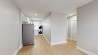 Located at 1315 NE Miami Ct in Miami, FL, this efficiently designed one-bedroom, one-bathroom unit offers a well-organized layout across a single floor. Light wood-tone vinyl flooring runs throughout the space, providing a clean, cohesive aesthetic that enhances the bright, neutral palette of soft gray walls and crisp white trim.

The kitchen is thoughtfully appointed with white shaker-style cabinetry, light stone countertops, and a full suite of stainless steel appliances including a refrigerator, electric range, and over-the-range microwave. A subway-style tile backsplash adds a subtle decorative touch, while louvered closet doors offer additional storage access nearby.

The bedroom is a comfortable, well-proportioned space featuring a window that brings in natural light and a dedicated closet with bifold doors, providing practical storage. The room's simple, clean design makes it highly adaptable.

The bathroom is a standout feature, finished with floor-to-ceiling marble-look tile surrounding the tub-shower combination, a modern floating wood-toned vanity, and a small window that provides natural ventilation. The overall finish level is polished and contemporary.

The unit also includes an in-unit laundry area with a stacked washer and dryer, adding everyday convenience. The space presents a practical and updated living option in Miami's vibrant urban core.