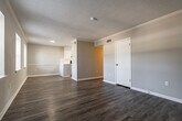 This 2-bedroom, 2-bathroom single-floor residence at 1420 Breckenridge Dr in Little Rock, AR offers a well-organized layout with modern finishes throughout. The living room welcomes you with durable wood-look vinyl flooring, crown molding, a textured ceiling, and multiple windows that invite natural light, creating a bright and open atmosphere. It flows seamlessly toward the kitchen, which is equipped with white cabinetry, quartz countertops, a classic subway tile backsplash, a stainless steel sink, and a black range — a clean, functional space suited for everyday cooking. Both bedrooms feature plush wall-to-wall carpeting and ceiling fans for year-round comfort. The primary bedroom includes a sliding glass door with vertical blinds opening to an outdoor view, while the secondary bedroom is served by a standard window with natural greenery visible outside. Each bathroom is appointed with a full tub-shower combination and clean white fixtures; one bathroom includes a vanity with quartz countertop and wood-look flooring, adding a touch of refinement. A connecting hallway ties the private areas together efficiently. Throughout the home, neutral gray tones, white trim, and consistent finishes contribute to a cohesive and contemporary aesthetic.