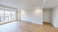 Located at 8 Walker Ave in Halifax, Nova Scotia, this well-appointed 2-bedroom, 2-bathroom unit offers a thoughtfully designed single-level layout with modern finishes throughout. Warm hardwood-style flooring flows seamlessly across all living areas, complementing the clean white walls and creating a bright, cohesive aesthetic.

The kitchen is a standout feature, boasting two-tone cabinetry with matte navy upper cabinets and natural wood lower cabinets, a marble-style backsplash, quartz countertops, stainless steel appliances, and a bold navy island with an integrated sink. The open living area is generously proportioned, equipped with a wall-mounted mini-split system and baseboard heating, and offers direct access to a private balcony through a sliding glass door.

The primary bedroom is spacious, featuring a large window with outdoor views and ample room to furnish comfortably. The second bedroom also benefits from a bright window and baseboard heating. Each bedroom connects conveniently to its own bathroom — the ensuite features a large-format tiled walk-in shower, while the second bathroom offers a full soaker tub/shower combo — both finished with light wood vanities and black hardware accents. A dedicated closet and in-unit laundry complete this well-rounded home.