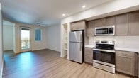 Located at 2650 Wagon Wheel Road in Oxnard, CA, this 2-bedroom, 1-bathroom unit offers a well-designed layout with modern finishes throughout. Light wood-style flooring flows consistently across all rooms, creating a cohesive and clean aesthetic.

The kitchen is a standout feature, equipped with a full suite of stainless steel appliances including a refrigerator, electric range, microwave, and dishwasher. Warm-toned shaker-style cabinetry provides ample storage, while white quartz countertops offer a crisp contrast. Recessed lighting illuminates the space efficiently.

The living area is bright and open, with neutral white walls, recessed lighting, and multiple electrical outlets positioned for flexible furniture arrangements. The space connects naturally to the rest of the unit.

Both bedrooms feature the same light wood-style flooring and neutral walls. The primary bedroom includes a ceiling fan and access to a private outdoor balcony, allowing natural light to fill the room. The secondary bedroom features a window with outdoor views of the surrounding neighborhood.

The bathroom is clean and modern, with a tub-shower combination finished in white subway tile, a wood-toned vanity with a white countertop, a large mirror, and matching flooring. A dedicated closet provides additional storage within the unit.