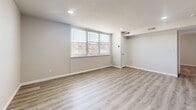 Located at 6000 Amberwood Road in Baltimore, MD, this one-bedroom, one-bathroom unit offers a well-organized layout across a single floor. Light-toned luxury vinyl plank flooring runs throughout, lending a clean, cohesive aesthetic to every room.

The living room is a bright, open space featuring recessed lighting, neutral gray walls, and multiple windows fitted with blinds that allow natural light to fill the room. The space provides a comfortable area for both relaxing and entertaining.

The kitchen is designed in a galley style, lined with white cabinetry accented by matte black hardware and topped with quartz-look countertops. A teal tile backsplash adds a pop of color, while stainless steel appliances — including an electric range and a full-size refrigerator — complete the modern setup. An in-unit stacked washer and dryer is also conveniently integrated into the unit.

The bedroom is a well-proportioned room with a corner window that brings in natural light. It features a closet with panel doors, direct access to the bathroom, and the same warm flooring found throughout the unit.

The bathroom includes a full soaking tub and shower combination, framed by large-format beige tiles with a decorative mosaic accent border, adding a refined touch to the space.