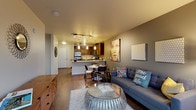 Located in Seattle's vibrant Ballard neighborhood, this fourth-floor residence at 1139 NW Market Street offers a well-designed, open-concept layout with contemporary finishes throughout. The kitchen is a standout feature, equipped with rich dark-wood cabinetry, granite countertops, stainless steel appliances including a refrigerator, electric range, microwave, and dishwasher, and elegant pendant lighting over the peninsula. The peninsula seamlessly connects to a dedicated dining area, making the space ideal for both everyday meals and entertaining. The living room is bright and inviting, featuring warm hardwood-style flooring, a neutral color palette with accent walls in deep gray-taupe tones, and large floor-to-ceiling sliding glass doors that open to a private balcony with tree-lined neighborhood views. The bedroom is a comfortable retreat with plush carpeting, a generous walk-in closet, and a large window that fills the room with natural light and outdoor views. The bathroom is finished with a dark-wood vanity, granite countertop, a large mirror with Hollywood-style lighting, and hardwood-style flooring. Track lighting throughout the main living area adds a modern, urban touch to this thoughtfully designed Ballard residence.