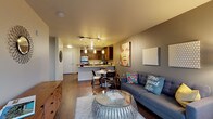 Located in Seattle's vibrant Ballard neighborhood, this fourth-floor residence at 1139 NW Market Street offers a well-designed, open-concept layout with contemporary finishes throughout. The kitchen is a standout feature, equipped with rich dark-wood cabinetry, granite countertops, stainless steel appliances including a refrigerator, electric range, microwave, and dishwasher, and elegant pendant lighting over the peninsula. The peninsula seamlessly connects to a dedicated dining area, making the space ideal for both everyday meals and entertaining. The living room is bright and inviting, featuring warm hardwood-style flooring, a neutral color palette with accent walls in deep gray-taupe tones, and large floor-to-ceiling sliding glass doors that open to a private balcony with tree-lined neighborhood views. The bedroom is a comfortable retreat with plush carpeting, a generous walk-in closet, and a large window that fills the room with natural light and outdoor views. The bathroom is finished with a dark-wood vanity, granite countertop, a large mirror with Hollywood-style lighting, and hardwood-style flooring. Track lighting throughout the main living area adds a modern, urban touch to this thoughtfully designed Ballard residence.