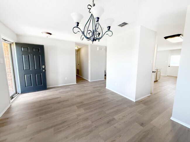 Entrada principal/comedor formal con vista al pasillo que conduce a los dormitorios secundarios/baño. - 1419 Windy Meadows Dr