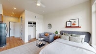 This well-appointed studio in Salem, Oregon offers a smart, efficient layout across a single floor, making excellent use of every square foot. The main living area seamlessly combines sleeping, lounging, and living functions, featuring warm-toned hardwood flooring, crisp white walls, and soaring ceilings that lend an open, airy feel. A ceiling fan adds both comfort and style overhead. A spacious reach-in closet provides ample storage, while a dedicated wall shelf offers additional display space. Large floor-to-ceiling windows flood the room with natural light, and a private balcony door opens to sweeping outdoor views of the surrounding Salem landscape — a standout feature of the space.

The kitchen is thoughtfully designed with rich walnut-toned cabinetry, quartz countertops, a neutral tile backsplash, and matte black fixtures. Full appliances including an electric range, built-in microwave, and dishwasher make this kitchen as functional as it is attractive. In-unit stacked laundry is also conveniently included.

The bathroom features a clean, modern aesthetic with a warm wood vanity, white countertop, matte black faucet, and framed wall art, maintaining a consistent design language throughout. The overall ambiance is contemporary and welcoming, blending modern finishes with a warm, livable atmosphere.