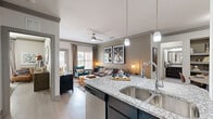 Located at 9440 Stratton Drive in Frisco, TX, this thoughtfully designed 2-bedroom, 3-bathroom residence offers a functional single-floor layout with modern finishes throughout. The open-concept living, dining, and kitchen area serves as the heart of the home, featuring light wood-look flooring, crown molding, and ceiling fans. The kitchen is outfitted with dark cabinetry, granite countertops, stainless steel appliances, a built-in pantry, and a peninsula with pendant lighting and bar seating — ideal for casual dining. The adjacent dining area accommodates a full table and features built-in shelving, while the living room provides generous natural light through multiple windows. The spacious primary bedroom includes a ceiling fan, large window, and access to an en-suite bathroom with a glass-enclosed walk-in shower and subway tile detailing. The second bedroom features light flooring, a ceiling fan, and natural light. The additional bathrooms include a soaking tub with classic white subway tile surround. A dedicated laundry area, four closets, and a hallway complete the layout, offering ample storage throughout this efficiently designed Frisco residence.