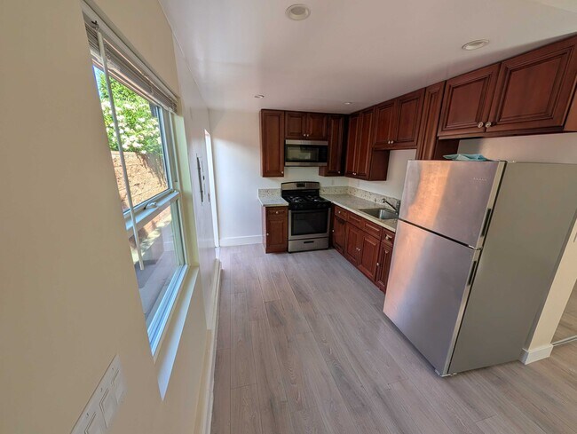 Cocina completa con electrodomésticos de acero inoxidable y encimeras de granito. - 6534 Peterson Ave