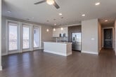 Located in Atlanta's vibrant Glenwood Park neighborhood, this single-floor residence showcases a thoughtfully designed open-concept layout with modern finishes throughout. Rich hardwood-style flooring flows seamlessly through the main living and kitchen areas, anchoring the bright, airy atmosphere created by an abundance of large windows and natural light.

The kitchen is a standout feature, equipped with stainless steel appliances, two-tone cabinetry combining white upper cabinets and dark wood lower cabinets, a subway tile backsplash, and a generous granite-topped island with a built-in sink and pendant lighting. A set of glass-paned doors leads to a private balcony, extending the living space outdoors.

The open living area benefits from abundant natural light streaming through oversized windows, with a ceiling fan adding comfort. Bedrooms are finished with plush carpeting and feature windows that invite natural light. The primary bathroom offers a dual-sink vanity with granite countertops, large-format tile flooring, and a glass-enclosed walk-in shower with white subway tile. A secondary bathroom mirrors the same refined aesthetic. A dedicated in-unit laundry closet with a full-size washer and dryer adds everyday convenience. A well-lit hallway with clean white paneled doors connects all rooms cohesively.