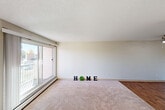 Located at 3830 105 Street NW in Edmonton, Alberta, this two-bedroom, one-bathroom unit offers a functional and well-organized single-floor layout. The entryway welcomes you with hardwood-style flooring and opens into the rest of the unit. The galley-style kitchen is efficiently designed with white cabinetry lining both sides, grey laminate countertops, a stainless sink, and white appliances including a full-size refrigerator — all finished with the same warm hardwood-style flooring. Adjacent to the kitchen is a dining nook with a ceiling fan, flowing naturally into the spacious living area. The living room is carpeted and filled with natural light from a large sliding glass door that leads to an outdoor balcony. Both bedrooms are carpeted and feature windows that bring in natural light, as well as louvred bi-fold closet doors offering ample storage. The primary bedroom is generously sized and includes a closet and convenient access toward the bathroom. The full bathroom features tile-surround tub and shower combo, wood-style flooring, and clean white fixtures. A textured ceiling is consistent throughout the unit, adding a classic residential character to the overall space.