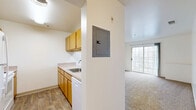 Located at 5711 Castlebridge Rd in Fredericksburg, Virginia, this one-bedroom, one-bathroom residence offers a practical and well-organized layout across a single floor. The open living area is finished with plush wall-to-wall carpeting and features a ceiling fan with light fixture, creating a comfortable and airy atmosphere. A large sliding glass door floods the living space with natural light and provides outdoor views. The kitchen is efficiently designed with warm honey-toned wood cabinetry, white appliances including a refrigerator, dishwasher, and range, a single-basin sink, and durable wood-look vinyl flooring that extends through the entryway and kitchen. A pass-through counter connects the kitchen to the living area, enhancing the open feel of the space. The bedroom is generously sized, featuring soft carpeting, a window that brings in natural light, and two closets with classic panel doors, offering ample storage. Two additional closets are found throughout the unit, providing practical storage solutions. The bathroom is finished with wood-look vinyl flooring, a single-sink vanity with warm wood cabinetry, and clean white fixtures. The overall aesthetic throughout the residence is bright and neutral, with crisp white walls and a clean, move-in-ready presentation.