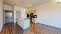 Located in Denver's vibrant Capitol Hill neighborhood, this one-bedroom, one-bathroom residence offers a thoughtfully designed open-concept layout with modern finishes throughout. The kitchen serves as a focal point of the living area, featuring a central island with a granite countertop and integrated sink, light maple cabinetry, a dark subway tile backsplash, stainless steel appliances, and stylish pendant lighting. Wood-style flooring extends throughout the main living areas, adding warmth and continuity to the space. The bedroom is a comfortable retreat finished with plush carpeting and a large window that frames views of the surrounding neighborhood and the Denver skyline beyond, allowing ample natural light to fill the room. A dedicated walk-in closet with wire shelving and hanging rods provides generous storage. The bathroom is well-equipped with a wide granite-topped vanity, dual sinks, a large mirror, wood-style flooring, and a soaking tub with tiled surround. A window in the bathroom adds a touch of natural light. The overall ambiance is clean, contemporary, and functional, making this residence a comfortable urban home in one of Denver's most walkable and established neighborhoods.