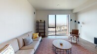 Located at 532 Union St in Oakland, CA, this modern single-floor residence offers a thoughtfully designed open-concept layout that seamlessly connects the living, dining, and kitchen areas. The living room is bright and inviting, anchored by large floor-to-ceiling sliding glass doors that frame expansive views of the Oakland cityscape, flooding the space with natural light and creating a strong indoor-outdoor connection. Warm hardwood-style flooring runs throughout, lending a cohesive and contemporary feel to the entire unit.

The kitchen is well-appointed with light wood cabinetry, white countertops, a stainless steel sink, and a full suite of stainless steel appliances including a gas range, microwave, and dishwasher. Recessed lighting overhead ensures a bright and functional cooking environment.

The bedroom is a cozy retreat featuring distinctive LED strip lighting accenting the headboard wall, creating a modern, ambient atmosphere. An adjacent full bathroom offers a combination tub and shower, tiled flooring, and clean white finishes, providing a practical and tidy space.

Overall, the unit presents a clean, modern aesthetic with neutral tones, contemporary fixtures, and functional design elements that make it a well-rounded urban living space in the heart of Oakland.