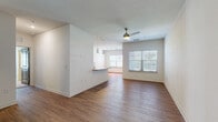 Located at 2439 Casona Ln in Melbourne, Florida, this single-floor residence offers a well-designed, open-concept layout with a clean, contemporary aesthetic throughout. The living and dining area is bright and spacious, featuring warm wood-look flooring, a textured ceiling, and a ceiling fan with light fixture. Large windows fitted with blinds allow ample natural light to fill the space, creating an inviting atmosphere. A ceiling-mounted track lighting system adds additional illumination over the adjoining areas.

The kitchen is outfitted with white shaker-style cabinetry extending to the ceiling, granite countertops, a subway tile backsplash, and a full suite of stainless steel appliances including a refrigerator, range, and over-the-range microwave. A breakfast bar with pendant lighting connects the kitchen to the main living area.

The bedrooms feature plush carpeting and generous proportions. The primary bedroom includes a ceiling fan, louvered closet doors, and access to a walk-in closet with wire shelving systems offering ample storage. The bathroom is finished with wood-look flooring, a granite-topped vanity with modern cabinetry, a large mirror, and a tub-shower combination with white tile surround.