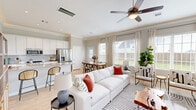 Located at 19302 Pradera Meadows Loop in Arcola, TX, this two-story home offers a thoughtfully designed layout spread across two floors. The main level welcomes you with a light-filled hallway featuring warm hardwood-style flooring, crisp white trim, and a staircase with a classic wood banister that sets an inviting tone throughout. The open-concept living area flows seamlessly into the kitchen and dining room, with large windows flooding the space with natural light. The kitchen is equipped with granite countertops, white cabinetry, stainless steel appliances, and a central island with a sink — ideal for both everyday cooking and entertaining. The adjacent dining room enjoys abundant window views, while a flexible den provides additional living or workspace. A powder bathroom with marble-tile flooring and a pedestal sink is conveniently located on the main floor. Upstairs, three bedrooms are complemented by four closets, a full bathroom, and a laundry room. The primary bedroom offers a generous footprint with ample natural light. Additional highlights include a pantry, a hallway, and an attached two-car garage with a water heater. Crown molding and ceiling fans are featured throughout, contributing to the home's polished, modern aesthetic.