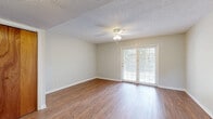 Located at 215 McMillan Ave in Bay Minette, Alabama, this two-story home offers two bedrooms and two bathrooms spread across two well-proportioned floors. The main level hosts the combined kitchen and living area, while the upper level accommodates the bedrooms and additional living space.

The living room is a bright, open space featuring warm hardwood-style flooring, a ceiling fan with light fixture, and a set of classic French doors that invite natural light and provide outdoor access. Neutral wall tones throughout the home create a clean, versatile backdrop.

The kitchen is efficiently designed with wood cabinetry, white countertops, a coil electric range, a dishwasher, and a double-basin sink beneath a window. Ample upper and lower cabinet storage makes the most of the available space.

The primary bedroom is a generously sized retreat with hardwood-style flooring, a ceiling fan, a large window with natural views, and two double-door closets offering substantial storage. The second bedroom also features hardwood-style floors and a ceiling fan.

Both bathrooms are functional and straightforward, with one featuring a tub-shower combination, a white vanity, and hardwood-style flooring. A connecting hallway ties the layout together efficiently. Throughout the home, textured ceilings and consistent flooring provide a cohesive, practical aesthetic.