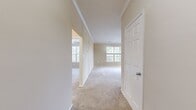 This well-appointed 1,010 square foot single-floor residence features 2 bedrooms, 2 bathrooms, and a thoughtfully designed layout. The living area is finished with plush wall-to-wall carpeting and crown molding, with a large window allowing natural light to fill the space. A hallway connects the main living areas to the bedrooms, each carpeted and equipped with ceiling fans. The primary bedroom measures 190 square feet, and both bedrooms offer dedicated closets. The kitchen is outfitted with dark espresso cabinetry, granite countertops, a tiled backsplash, stainless steel appliances including a gas range, built-in microwave, and refrigerator, and durable tile flooring. The two bathrooms feature a consistent design with white vanity cabinetry, a soaking tub and shower combination with white subway tile accented by a decorative mosaic border, and neutral gray tile flooring. A dedicated in-unit laundry room houses a full-size washer and dryer with overhead wire shelving. The unit also includes a private balcony enclosed by a black metal railing, offering serene, elevated views of mature surrounding trees.