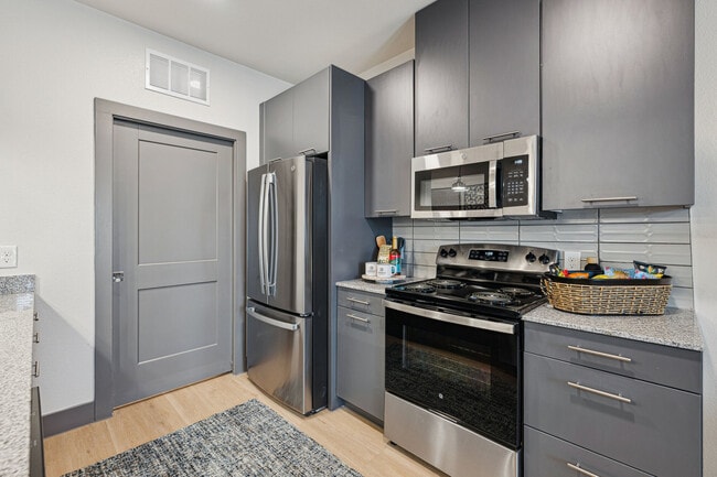 Kitchen with Gray Cabinets and Stainless Steel Appliances - Legacy at Veramendi
