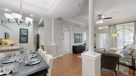Located at 1919 Post Oak Park Dr in Houston, TX, this well-appointed three-bedroom, two-bathroom residence offers a thoughtfully designed single-floor layout. The open-concept living and dining area is anchored by distinctive decorative columns and warm hardwood flooring, creating an inviting, flowing space filled with natural light from large windows. Crown molding and ceiling fans add refined finishing touches throughout.

The formal dining area accommodates a full-sized dining table beneath an elegant chandelier, while a built-in bookcase and patio access enhance the comfortable living room. The kitchen features white cabinetry with under-cabinet lighting, granite countertops, a tile backsplash, stainless steel appliances, and a convenient breakfast bar.

The spacious primary bedroom offers soaring ceilings and plush carpeting, providing a serene retreat. Additional bedrooms also feature vaulted ceilings and ample closet space. The primary bathroom is outfitted with a dual-sink vanity topped with granite, white cabinetry, and tile flooring, offering both style and functionality.

With two dedicated closets, neutral tones throughout, and quality finishes in every room, this residence delivers a comfortable and polished living experience in one of Houston's desirable neighborhoods.