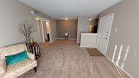 Located at 4625 71st St in Lubbock, TX, this single-floor unit offers a practical and comfortable layout designed for everyday living. The open-concept living area is generously sized, featuring plush carpeting, neutral taupe walls, and a fireplace that serves as a focal point. A sliding glass door floods the space with natural light and provides access to the outdoors. The transition between the entryway and living area is accented by wood-look flooring, adding visual contrast to the soft carpet throughout.

The galley-style kitchen is equipped with dark cabinetry, black appliances including a refrigerator and electric range, and a raised breakfast bar that connects to the main living space, making it ideal for casual dining or entertaining.

The bedroom is well-proportioned, featuring a ceiling fan with integrated lighting, neutral carpet, a textured ceiling, and a double-door closet offering ample storage. The room is adjoined by a full bathroom outfitted with wood-look flooring, a tiled tub and shower combination, and a toilet — all within a clean, efficient layout.

Throughout the unit, a consistent neutral color palette, textured ceilings, and functional finishes create a cohesive and move-in-ready environment suited for comfortable residential living.