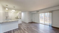 Located at 2200 Chateau Ct in Richmond, VA, this two-bedroom, one-bathroom home offers a well-designed single-floor layout with clean, modern finishes throughout. The open-concept living and kitchen area is anchored by warm wood-tone luxury vinyl plank flooring that flows seamlessly through the entire unit. The kitchen features crisp white shaker cabinetry, granite-style countertops, a peninsula with pendant lighting ideal for casual dining, and white appliances. A large sliding glass door floods the living area with natural light and opens directly onto a private balcony overlooking a serene, tree-lined backdrop of tall pines — a notably peaceful outdoor setting. The two bedrooms are comfortably sized, with the primary offering ample room, and both feature neutral white walls and the same consistent flooring. Three closets provide generous storage throughout the unit. The full bathroom includes a tub/shower combo and built-in shelving for added convenience. A dedicated den offers flexible space for a home office or additional living area. In-unit laundry, a hallway connecting the rooms, and a well-organized layout complete this functional and attractively finished home.