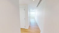 Located in the heart of downtown Edmonton at 102 Street NW, this modern one-bedroom, one-bathroom unit offers a well-designed layout across a single floor. The open-concept kitchen is a standout feature, boasting high-gloss white cabinetry extending to the ceiling, a light blue mosaic tile backsplash, grey quartz countertops, stainless steel appliances, and a portable island that adds both prep space and storage. Light oak hardwood flooring runs throughout, lending warmth to the clean, contemporary aesthetic. The bedroom is a bright, functional space with sliding double closet doors and easy access to the hallway. The bathroom is finished with large-format marble-look wall tiles, a soaker tub with a rainfall showerhead, a sliding glass enclosure, and warm wood-toned cabinetry. A private balcony extends the living space outdoors. The unit's most dramatic feature is its sweeping floor-to-ceiling windows, which frame breathtaking panoramic views of the Edmonton skyline and river valley beyond. Natural light pours in throughout the day, enhancing the crisp, minimalist interiors and creating a bright, airy ambiance suited to urban living.