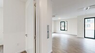 Located at 125 South Harrison Street in East Orange, NJ, this well-designed one-bedroom, one-bathroom residence offers a clean, contemporary aesthetic across a single floor. The open-concept kitchen and living area serves as the heart of the unit, featuring light wood-look flooring, crisp white walls, and abundant natural light from large dark-framed windows. The kitchen is outfitted with stainless steel appliances — including a range, over-the-range microwave, and dishwasher — complemented by two-tone cabinetry with glossy white upper cabinets, wood-toned lower cabinets, and a subway tile backsplash. A ceiling-mounted HVAC unit ensures year-round comfort in the living space, which opens directly onto a private balcony through sliding glass doors. The bedroom is a well-proportioned, quiet retreat with its own window providing natural light and neighborhood views. Two closets offer generous storage throughout the unit. The bathroom features wood-look flooring, a white vanity with mirrored medicine cabinet, and clean, minimal finishes. A dedicated utility room completes the layout. The overall design is modern and move-in ready, with a neutral palette and quality finishes throughout.