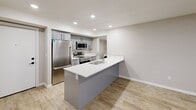 Located in the sought-after Sage Hill neighbourhood of Calgary, this well-appointed 2-bedroom, 2-bathroom unit offers a clean, modern aesthetic with thoughtful finishes throughout. The open-concept living area connects seamlessly to a stylish kitchen, which features a peninsula with a double stainless steel sink and white quartz countertops, grey cabinetry, a full suite of stainless steel appliances including a refrigerator, electric range, and built-in microwave, and a tiled backsplash. Light wood-look flooring runs throughout the main living areas, complementing the neutral colour palette and recessed lighting overhead. The living area extends toward a window that brings in natural light. Both bedrooms are comfortably sized, each featuring light wood flooring, a window with a roller blind, and baseboard heating. The unit includes two bathrooms: one with large-format white tile flooring, a quartz vanity, and a soaker tub with tub surround, and another featuring striking floor-to-ceiling marble-look porcelain tile in the walk-in shower with matte black hardware accents. A dedicated in-suite laundry room houses a side-by-side Samsung washer and dryer with overhead wire shelving for added storage. Two closets provide additional organization options, rounding out this functional and contemporary home.