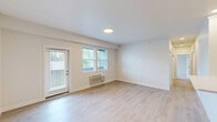 Located at 724 E Hastings Rd in Spokane, WA, this well-appointed two-bedroom, two-bathroom residence offers a thoughtfully designed single-level layout. The open living room is bright and airy, featuring light wood-style flooring, neutral walls, a wall-mounted HVAC unit, and a glass door that opens to the outdoors, allowing natural light to fill the space. The kitchen is equipped with rich dark wood cabinetry, stainless steel appliances including a full-size refrigerator, microwave, and range, along with light countertops and matching wood-style flooring for a cohesive look. Both bedrooms are carpeted and receive natural light through sizable windows with views of surrounding greenery. The spacious primary bedroom includes a generous walk-in closet fitted with wire shelving along multiple walls, providing ample storage. The bathrooms are finished with dark wood vanity cabinets, light countertops, and brushed nickel fixtures, with one bathroom featuring a full tub-shower combination. A dedicated laundry room includes a full-size washer and dryer, upper cabinetry, and countertop space for added convenience. Clean, modern finishes and a functional floor plan define this comfortable Spokane residence.