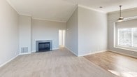 Located at 26371 Paloma in Lake Forest, California, this single-story home offers a thoughtfully designed layout with a blend of comfort and functionality. The spacious living room immediately draws attention with its soaring vaulted ceilings adorned with crown molding, a tile-surround fireplace as the focal point, and soft neutral-toned carpet underfoot. A sliding glass door fills the adjoining area with natural light and provides access to the outdoors, enhancing the open, airy feel of the main living space.

The kitchen is well-appointed with crisp white cabinetry, gray countertops, and a full suite of stainless steel appliances including a range, microwave, and refrigerator. Durable wood-look flooring ties the kitchen together, and a peninsula counter offers a convenient casual dining or prep area.

The bedrooms are generously sized, each featuring plush carpet, vaulted or elevated ceilings, and windows with blinds that invite natural light while maintaining privacy. The bathrooms include a walk-in shower stall in one and a full tub-shower combination in another, both finished with clean, neutral tones and wood-look flooring. This home presents a clean, move-in ready interior throughout.