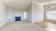 Located at 26371 Paloma in Lake Forest, California, this single-story home offers a thoughtfully designed layout with a blend of comfort and functionality. The spacious living room immediately draws attention with its soaring vaulted ceilings adorned with crown molding, a tile-surround fireplace as the focal point, and soft neutral-toned carpet underfoot. A sliding glass door fills the adjoining area with natural light and provides access to the outdoors, enhancing the open, airy feel of the main living space.

The kitchen is well-appointed with crisp white cabinetry, gray countertops, and a full suite of stainless steel appliances including a range, microwave, and refrigerator. Durable wood-look flooring ties the kitchen together, and a peninsula counter offers a convenient casual dining or prep area.

The bedrooms are generously sized, each featuring plush carpet, vaulted or elevated ceilings, and windows with blinds that invite natural light while maintaining privacy. The bathrooms include a walk-in shower stall in one and a full tub-shower combination in another, both finished with clean, neutral tones and wood-look flooring. This home presents a clean, move-in ready interior throughout.