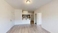 Located at 1900 Poplar St in Forest Grove, Oregon, this well-designed one-bedroom, two-bathroom unit offers a thoughtful single-level layout that maximizes every square foot of its compact footprint. The open-concept living and kitchen area serves as the heart of the home, with light-toned wood-look flooring flowing throughout the main spaces and large windows that invite natural light. A private exterior door from the living area provides convenient outdoor access.

The kitchen is a standout feature, equipped with stainless steel appliances — including a refrigerator, range, and over-the-range microwave — complemented by dark wood cabinetry and granite-style countertops. A raised breakfast bar provides casual seating and defines the kitchen's boundary with the living space. An open built-in shelving area adds functional storage nearby.

The bedroom is carpeted for warmth and comfort, features a large window with views of the surrounding neighborhood, and includes a dedicated closet with built-in shelving. Two bathrooms serve the unit, one of which includes a full soaking tub with shower and safety grab bar. The second bathroom features a granite-topped vanity and convenient access to an in-unit stacked washer and dryer. The overall aesthetic is clean, modern, and move-in ready.